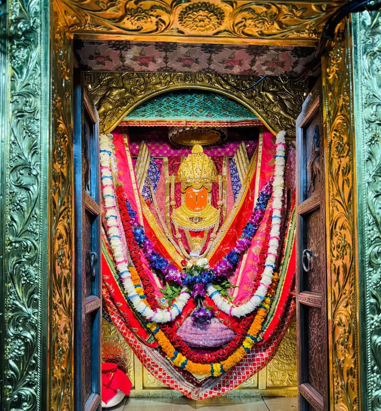 Darshan of Jeen Mata through the ornate silver and gold doors of the sanctum, draped in red chunari and flower garlands